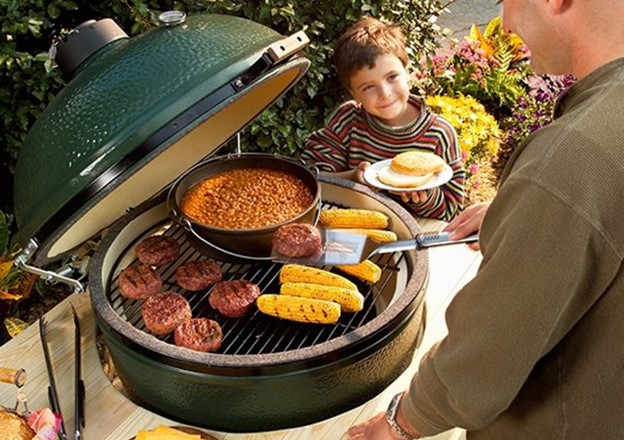 family using big green egg grills